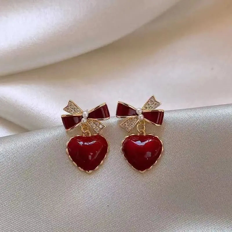 Pendientes de temperamento de nuevo estilo a la moda, pendientes de perlas de circón con forma de corazón de melocotón y lazo rojo vino, pendientes versátiles y exquisitos 2024